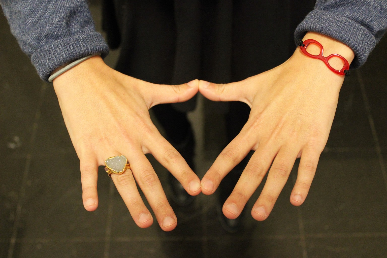 A student at Barnard College wears a bright red eyeglasses bracelet and a large gold and druzy stone ring.