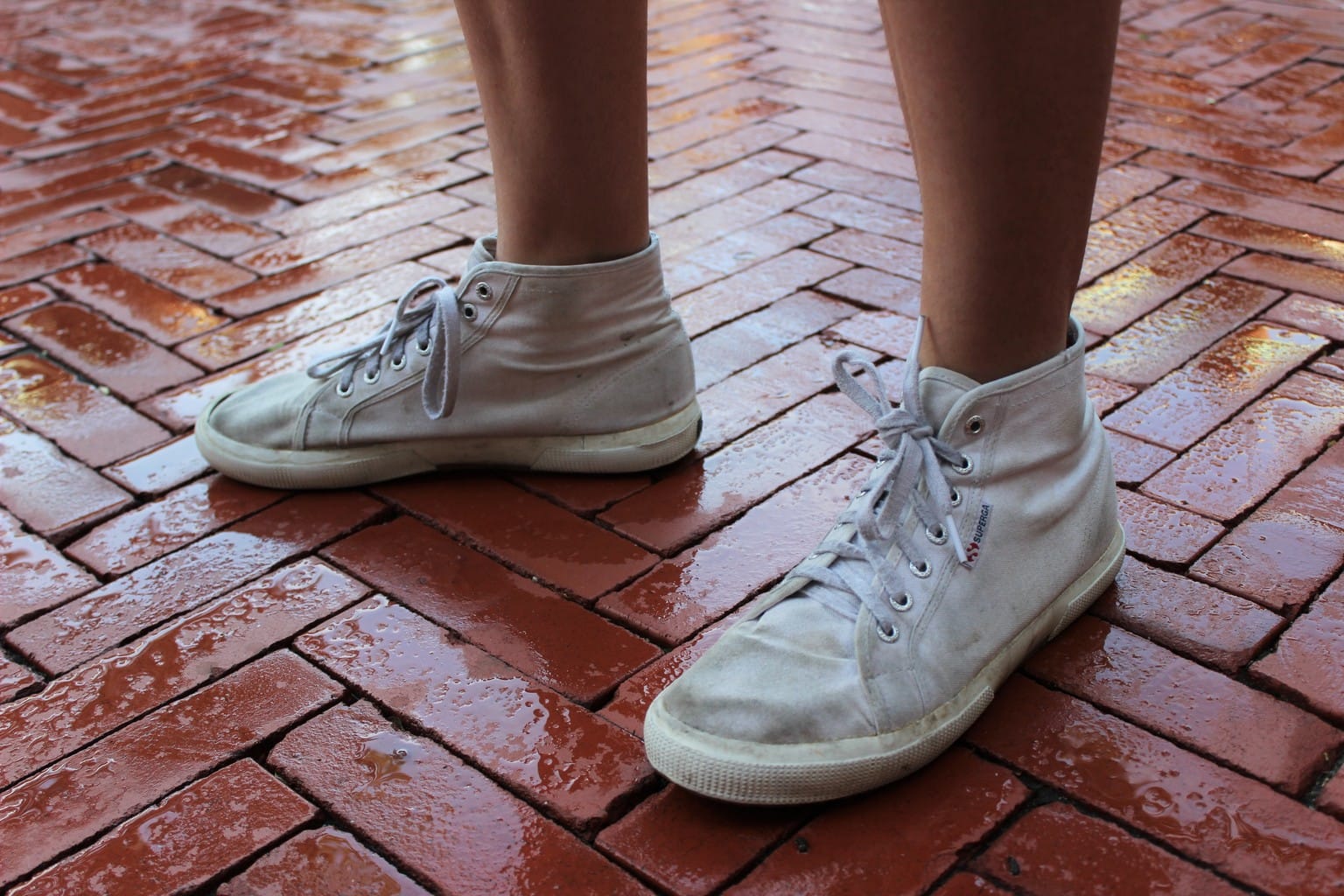 White high-top lace-up sneakers with rubber soles.