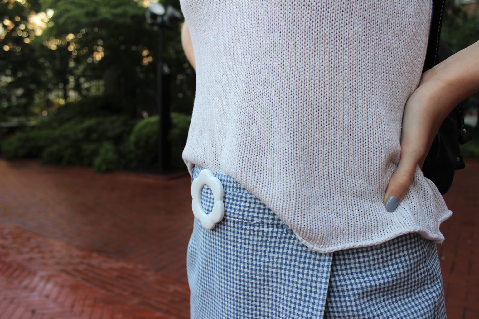 Skort style: blue and white checkered skort with faux flower belt buckle and heavy white knitted sweater-style tank top.