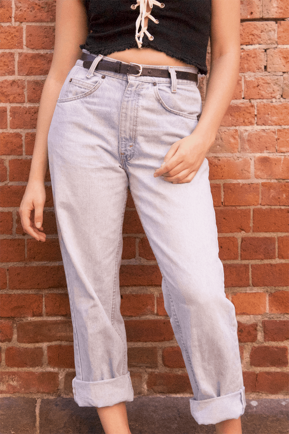 Student wears high-waisted and belted mom jeans with light wash and baggy fit.