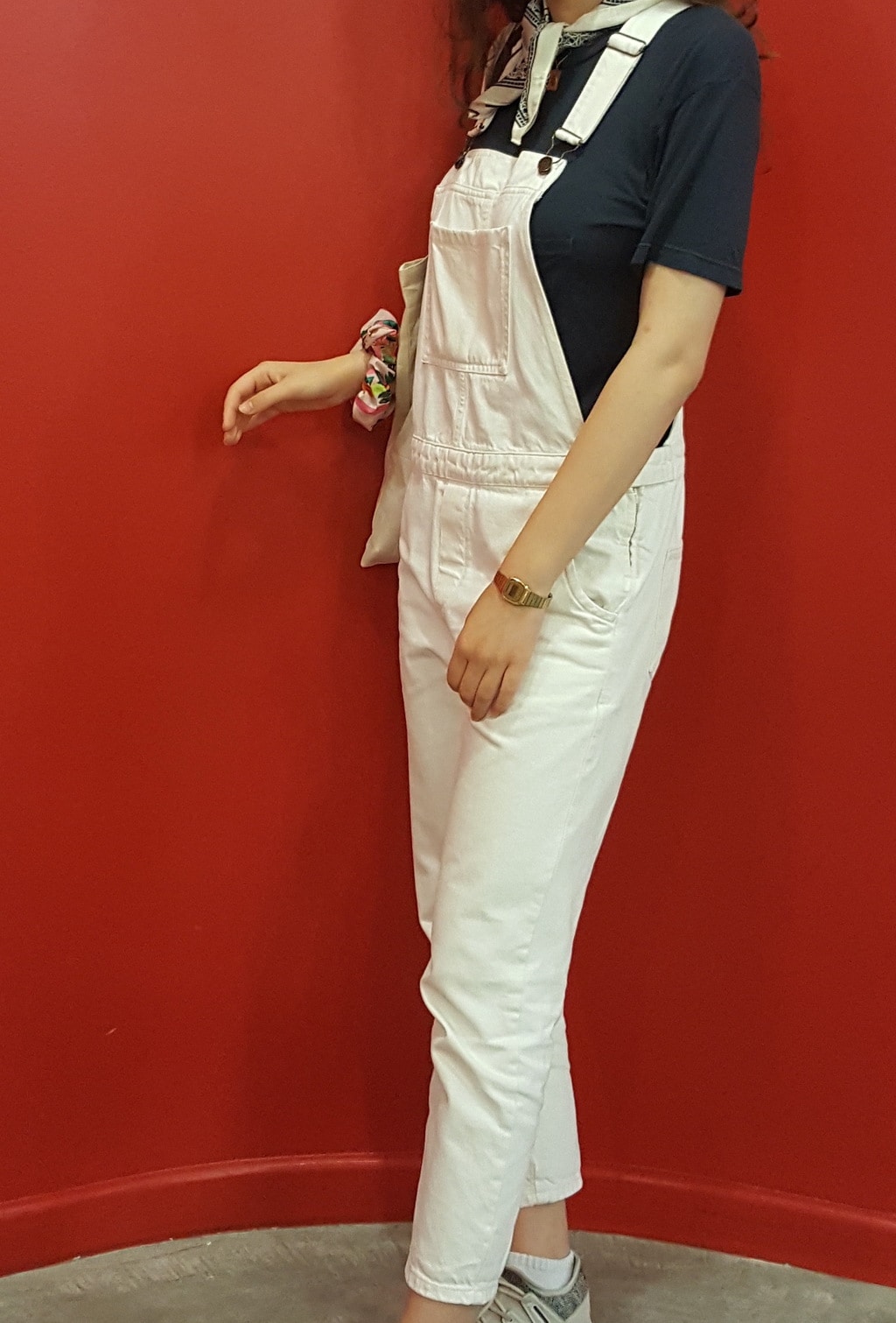 Cuffed white overalls paired with a short-sleeve navy t-shirt and a simple gold watch.