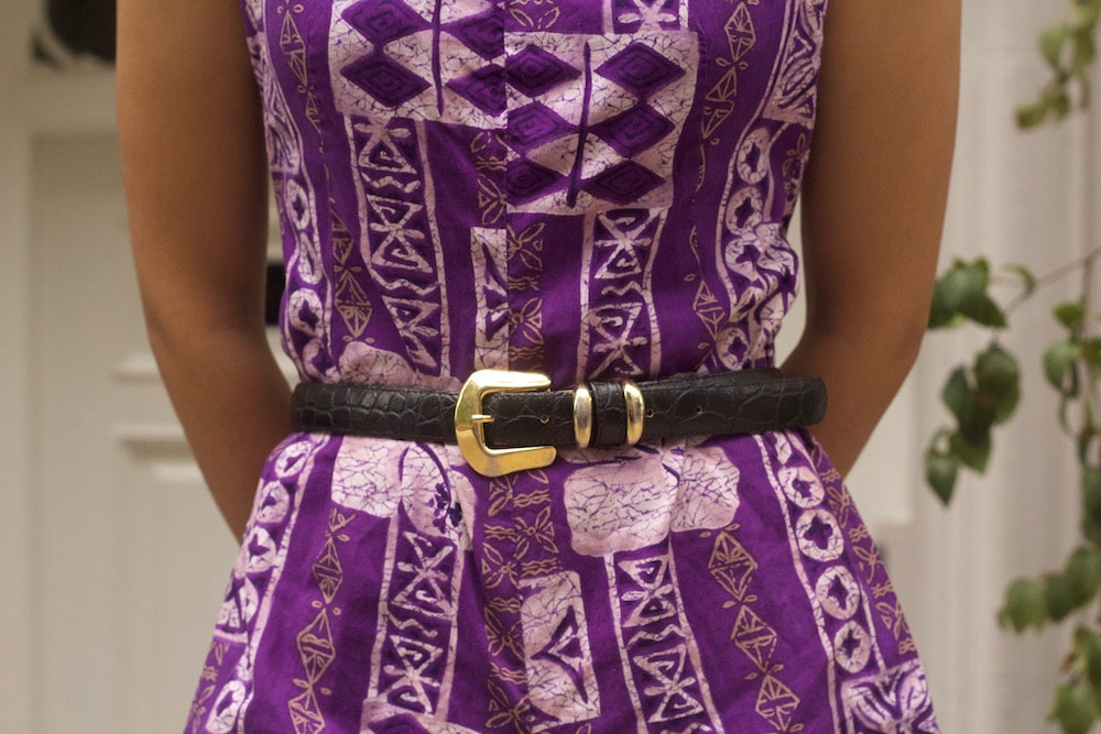 Small accents make a big impact; this brown western-style belt with shiny gold belt buckle polish off this purple romper.