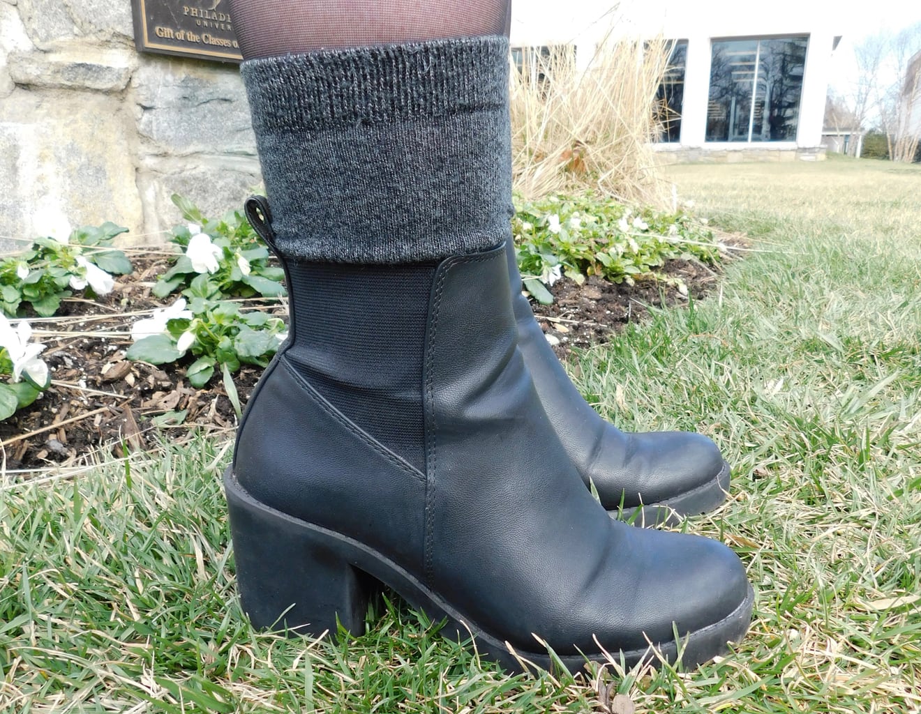 These black chunky-heeled booties with elastic detailing are accented with a pair of cozy grey boot socks.