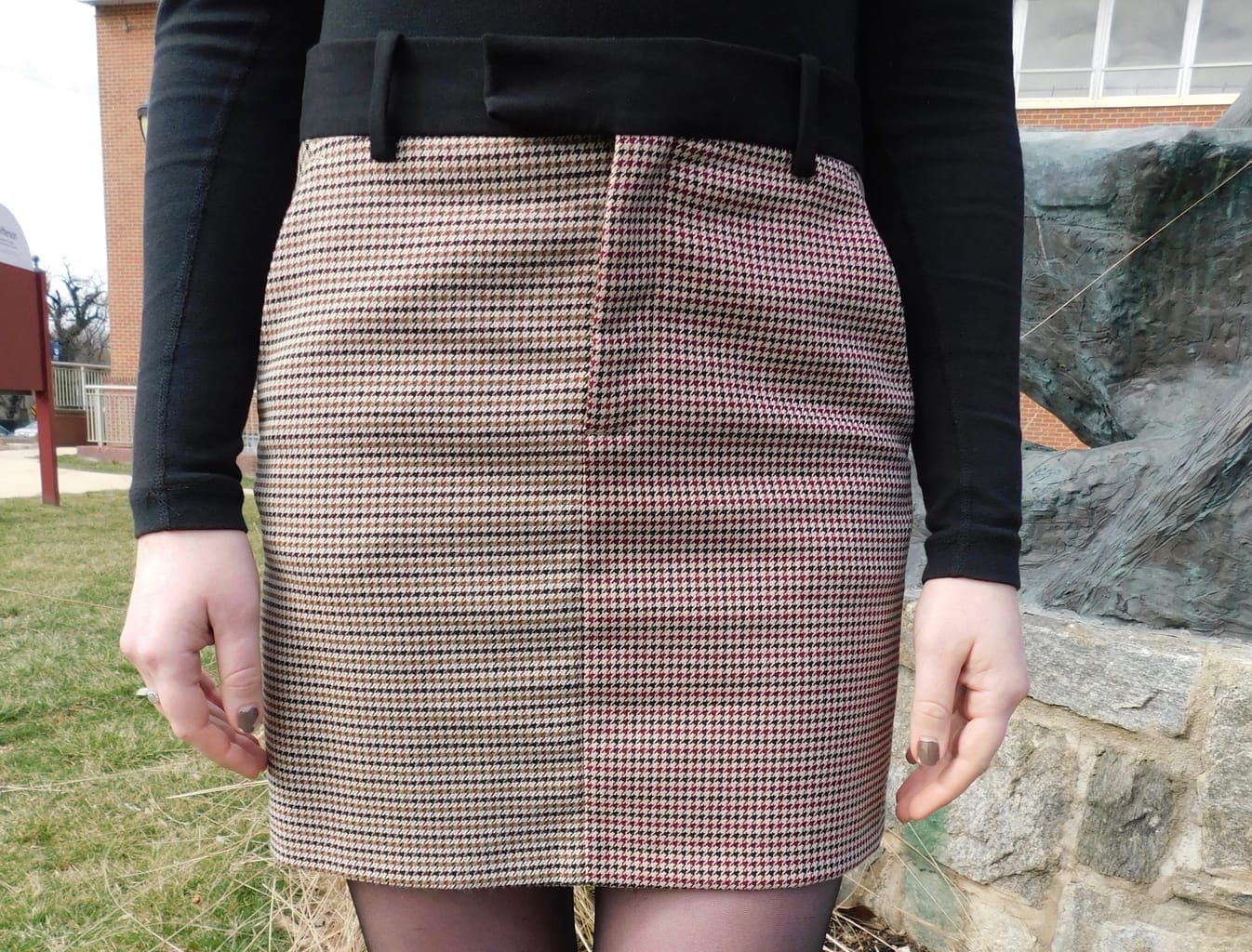 This black, white, and red houndstooth miniskirt has a black waistband.