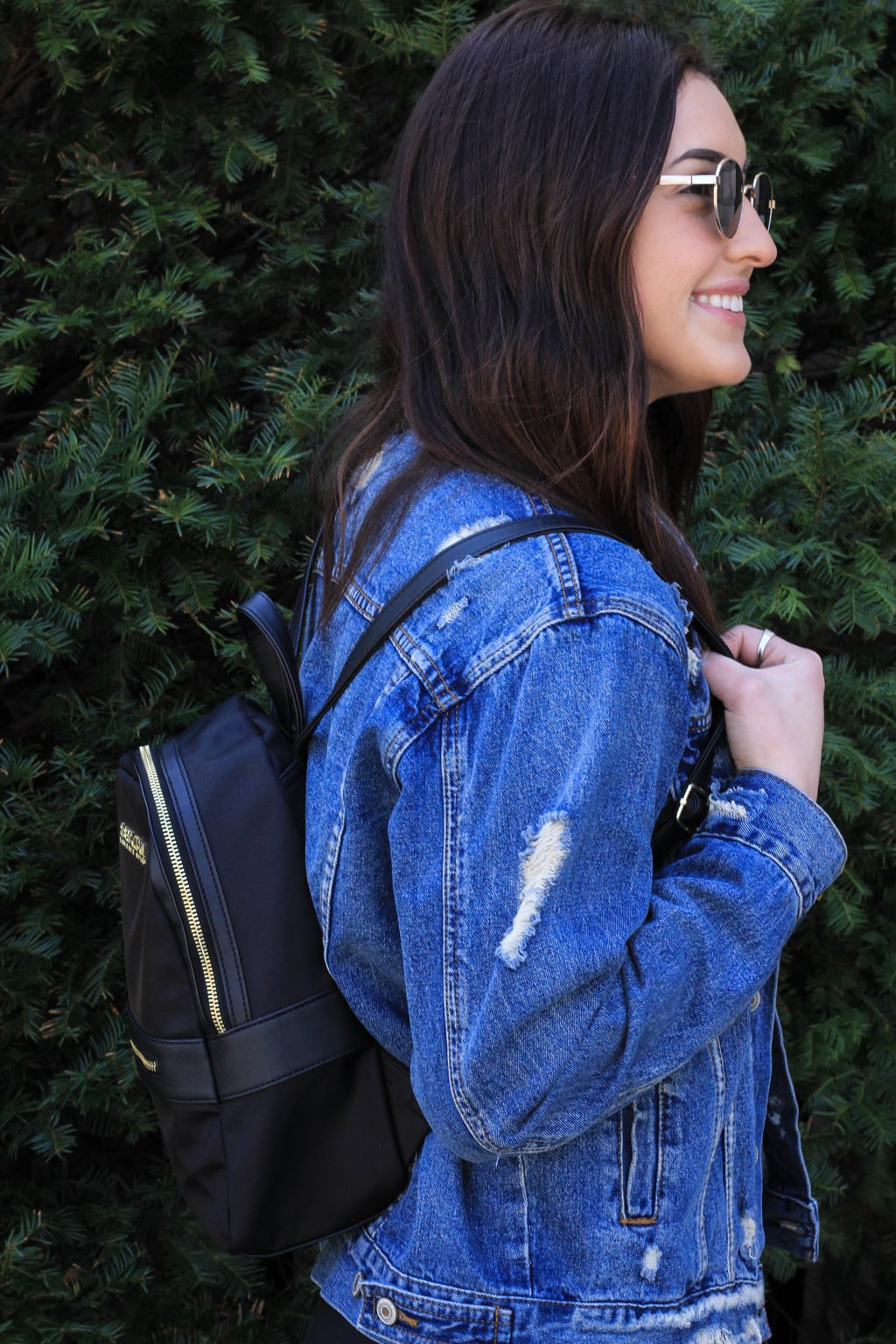 Bailey's black mini backpack with gold zippers and details carries everything she needs around campus.