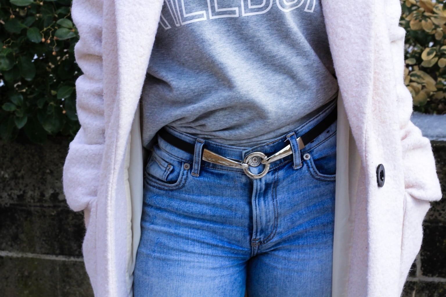 This vintage slim black belt is held together by a unique silver circle buckle.