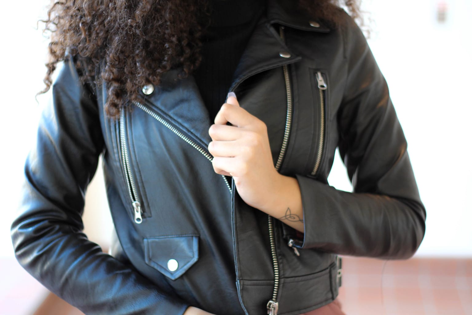 This motorcycle jacket with silver zippers and buttons is perfect for an outerwear piece around campus.