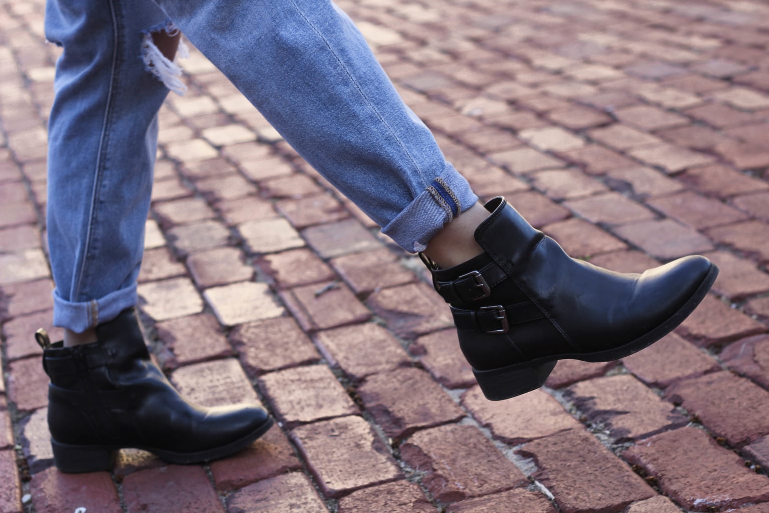 Maddie's black riding booties are flat with two silver buckles on the outside.