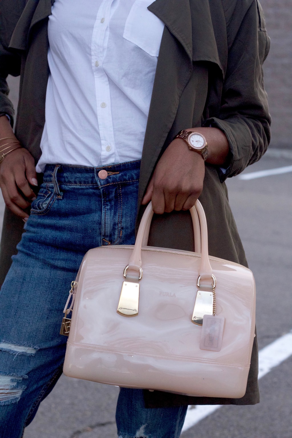 Ultra patent mini blush pink tote bag with gold details, worn with a copper watch.