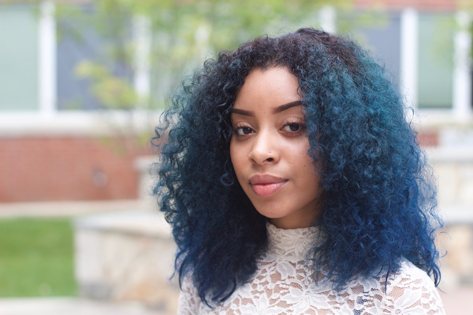Bright blue curly hair and fresh faced makeup on University of Bridgeport student Carol.