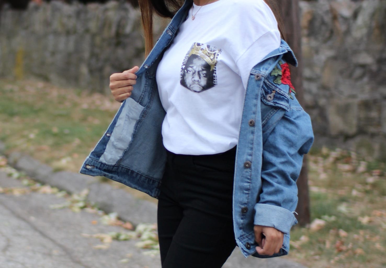 Tasfia's oversized plain white tee has a portrait graphic where a pocket would be. She wears it with a distressed light denim embroidered jacket.