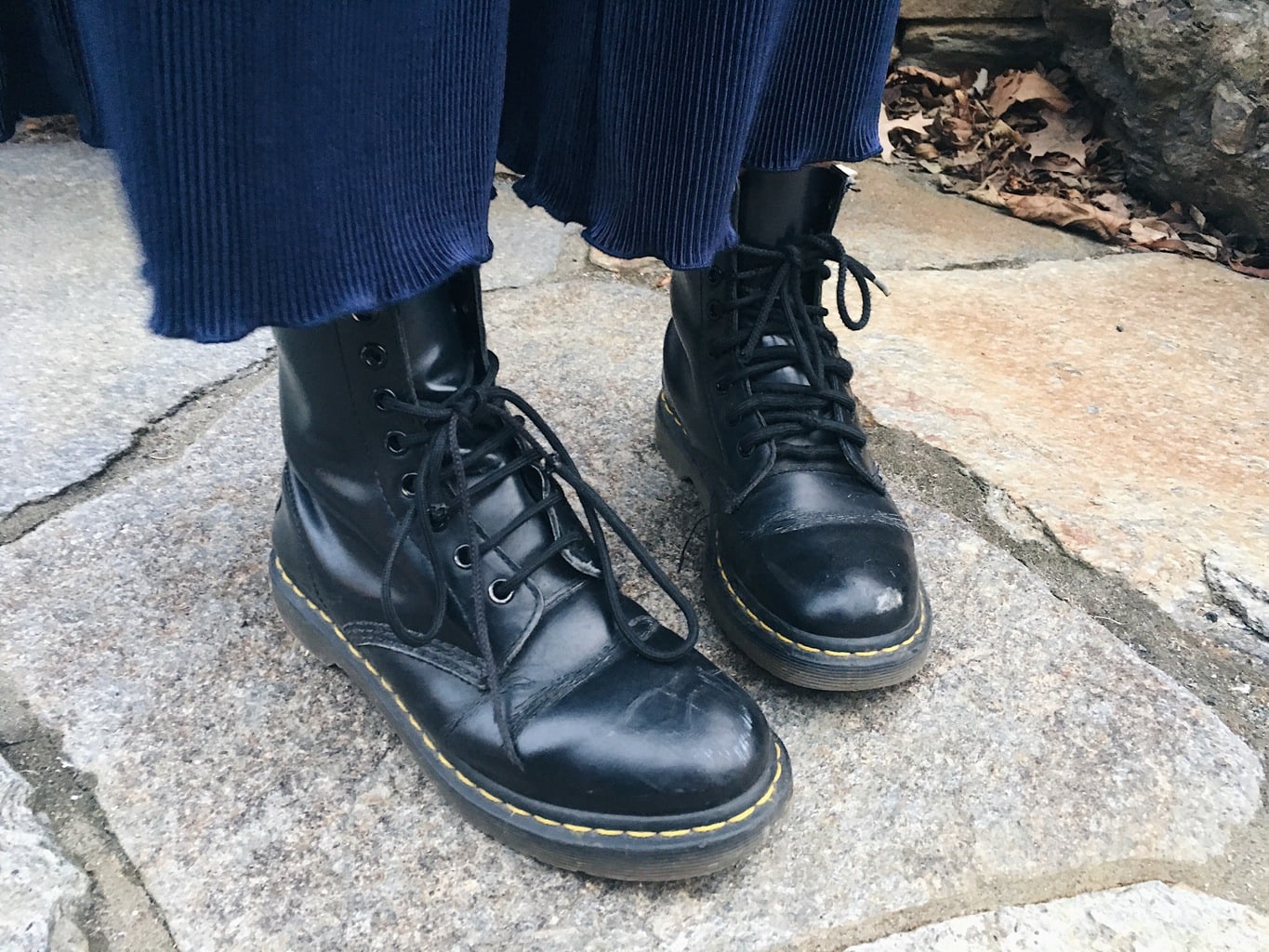 Caeli shows off her rugged black Doc Martens with rubber soles and black laces.