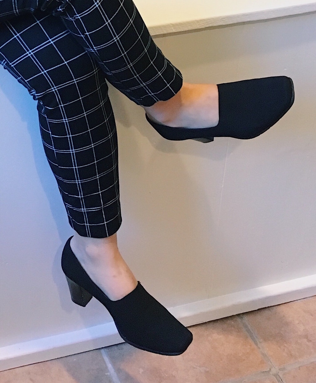 Yan Ni wears a pair of chunky-heeled black pumps that cover most of the top of her foot for comfort and modesty.