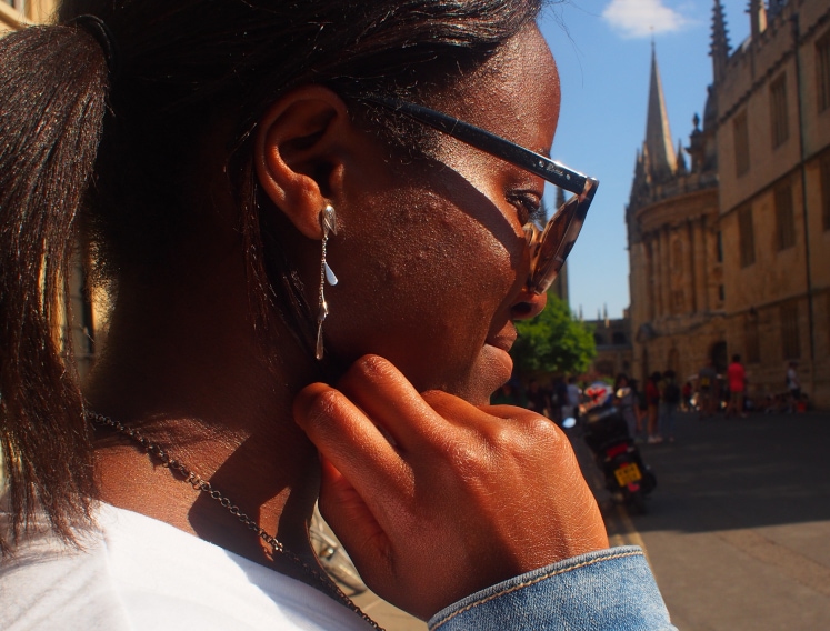 Chelsea wears simple gold chain dangle earrings.