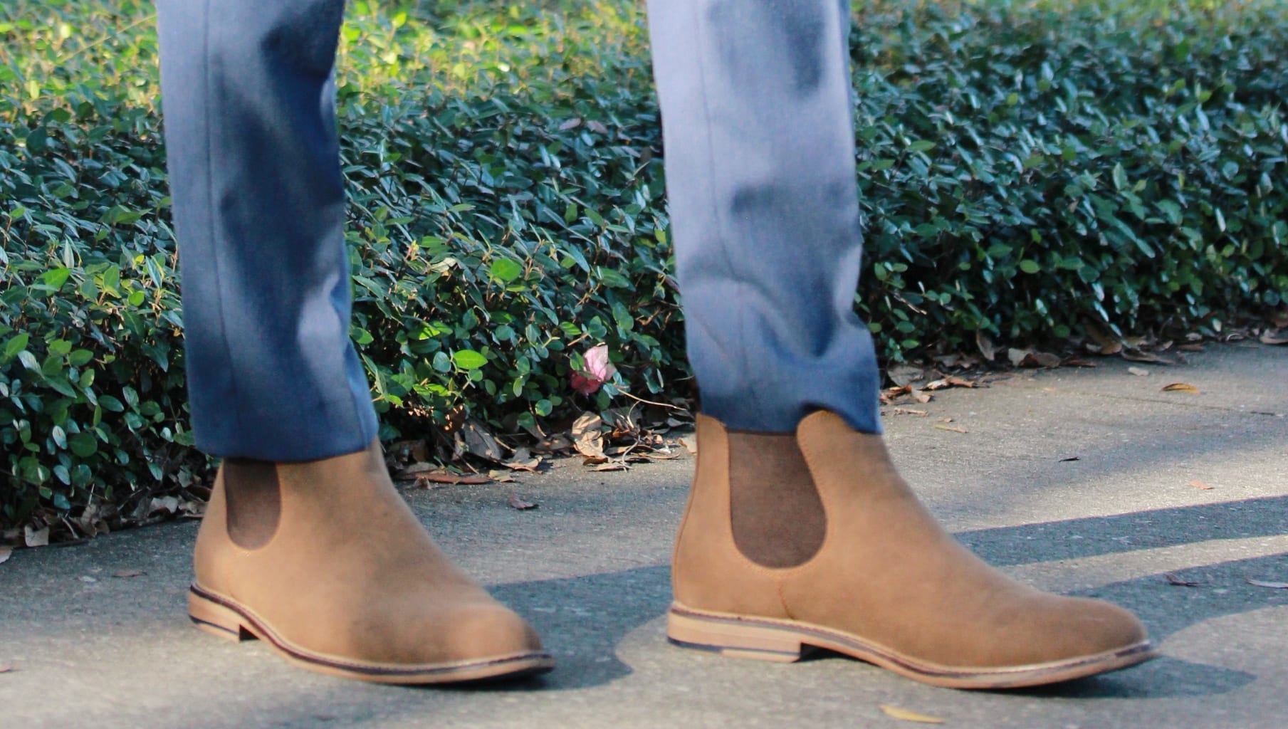 Flat tan brown Chelsea boots with slim fit blue slacks.