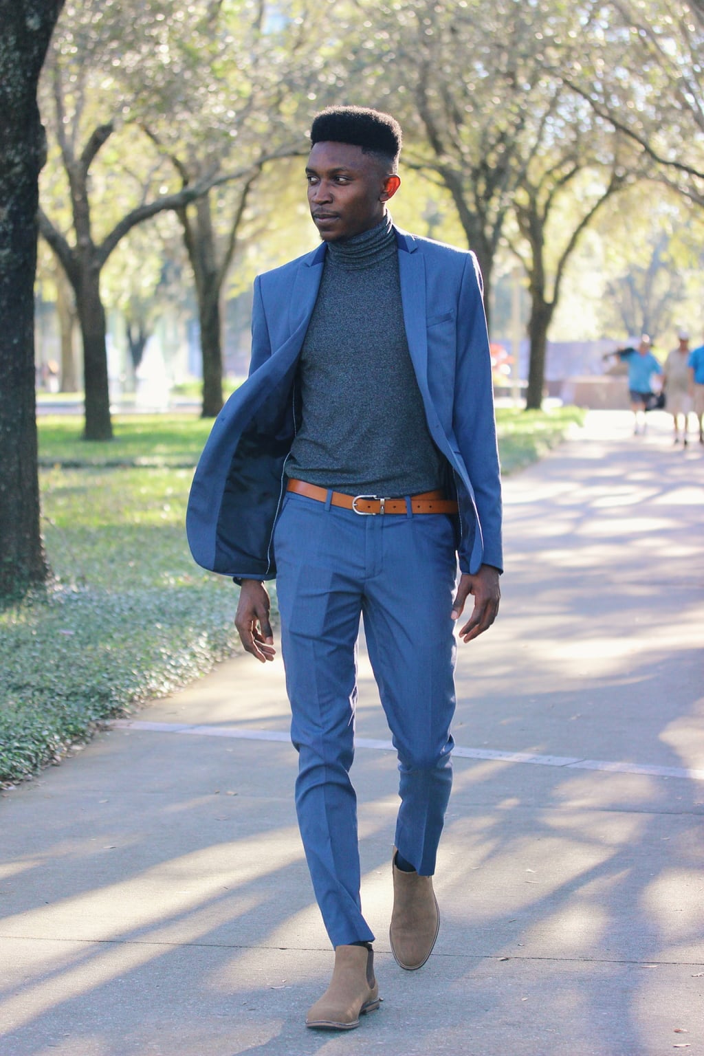 Dressed up for class, Adedamola wears a two-piece navy blue slim fit Zara suit with a heather grey turtleneck, ankle boots, and skinny brown belt.