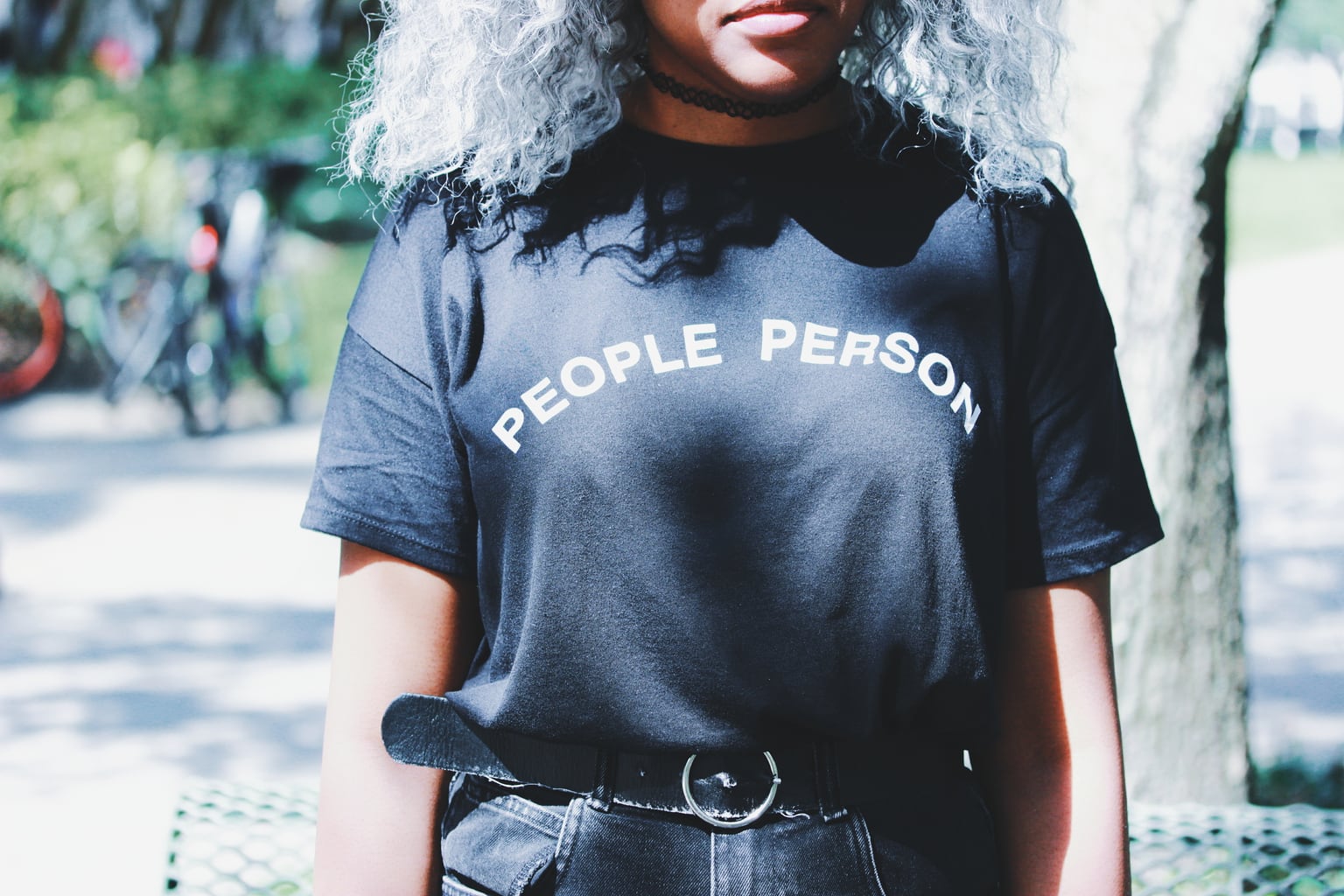Lundyn's unisex "People Person" tee is tucked into high-waisted and belted boyfriend shorts and a choker necklace.