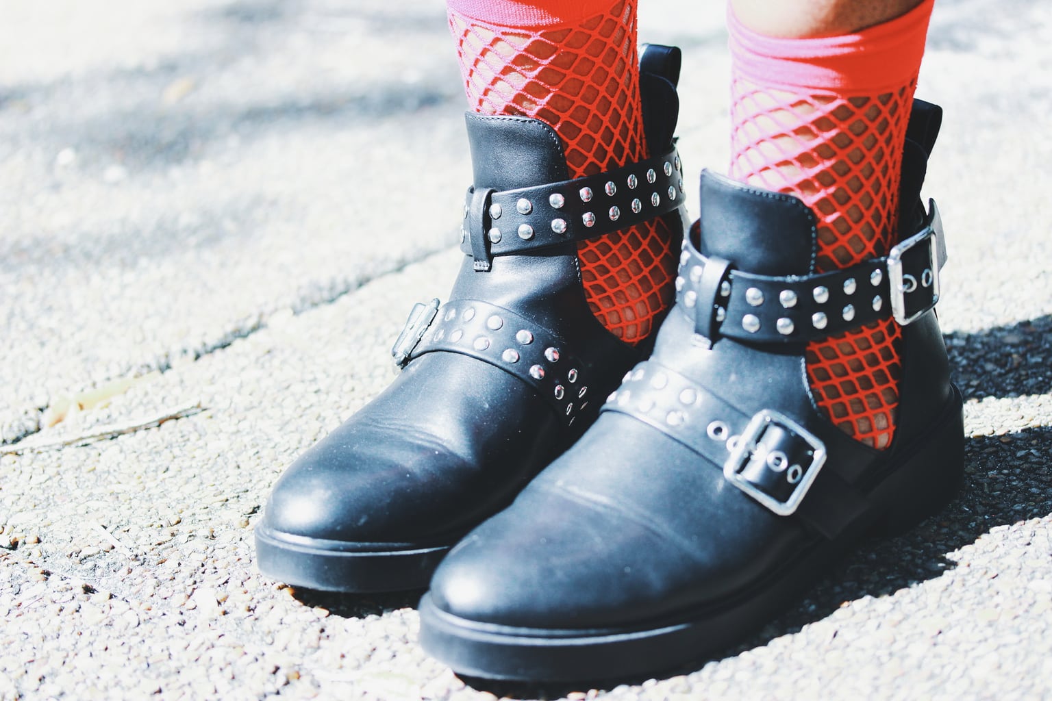 This student's look is polished off with flat studded sandal-boots with multiple buckles and red fishnet socks.