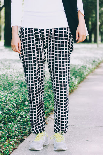 Black and white comfortable and loosely-fitted windowpane print trousers, paired with simple sneakers and neon green shoelaces.