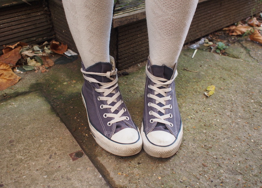 Sharen wears patterned white knee-high socks with low-top lilac Converse sneakers.