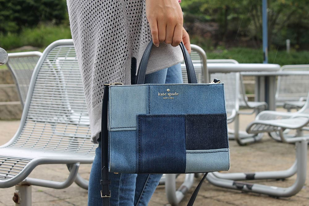 Alyssa wears a patchwork denim Kate Spade mini tote purse with a crossbody strap.