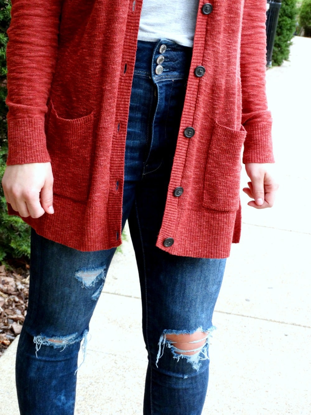 Long apple red cardigan with pockets contrasts against this West Virginia student's three-button denim jeans and basic grey t-shirt.