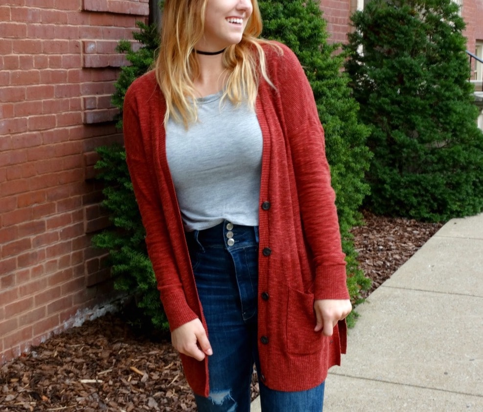 A cherry red long cardigan paired with high-waisted denim jeans and a light grey crew neck tee for fall.