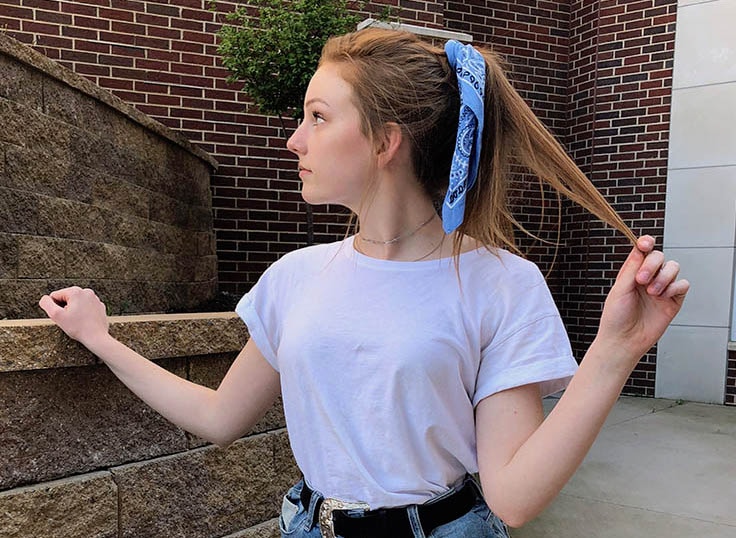 This West Virginia University student wears a traditional blue bandana tied around her ponytail with her white tee shirt.