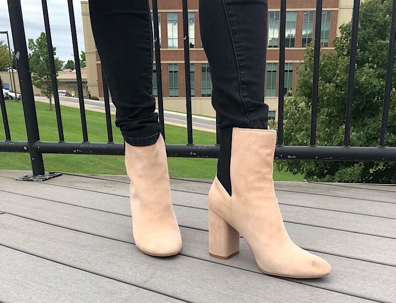 Gabriella wears black skinny jeans with tan heeled booties with black back panels.