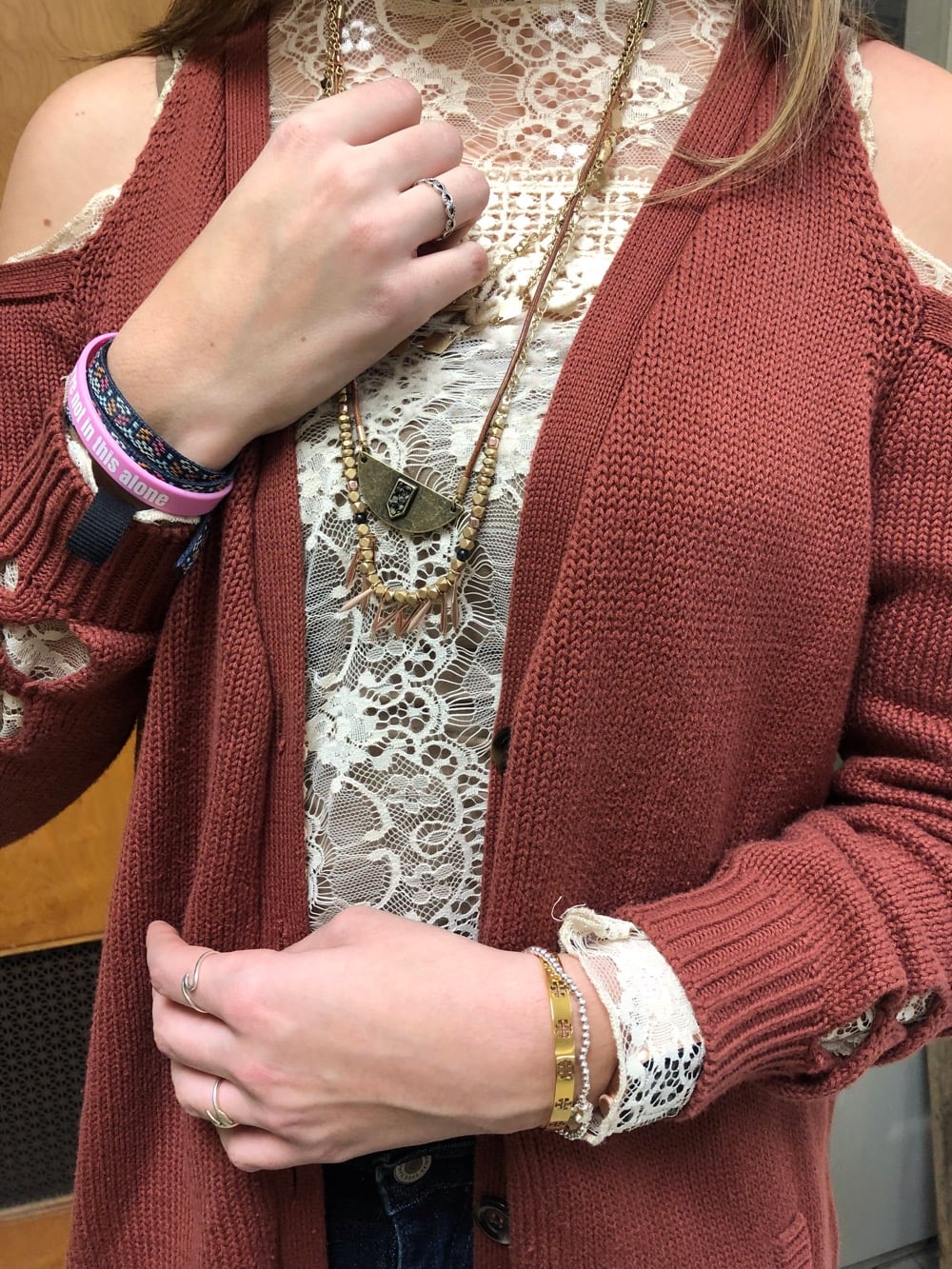 Gentry wears layers of bronze and gold beaded necklaces and mismatched bracelets.