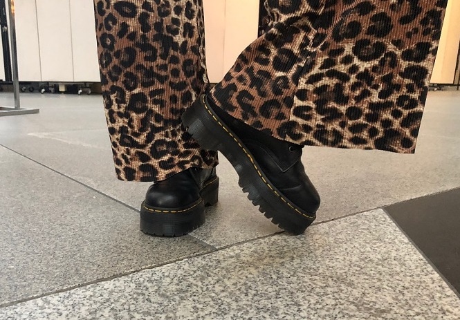 Hannah wears platform black Doc Marten sneaker boots.