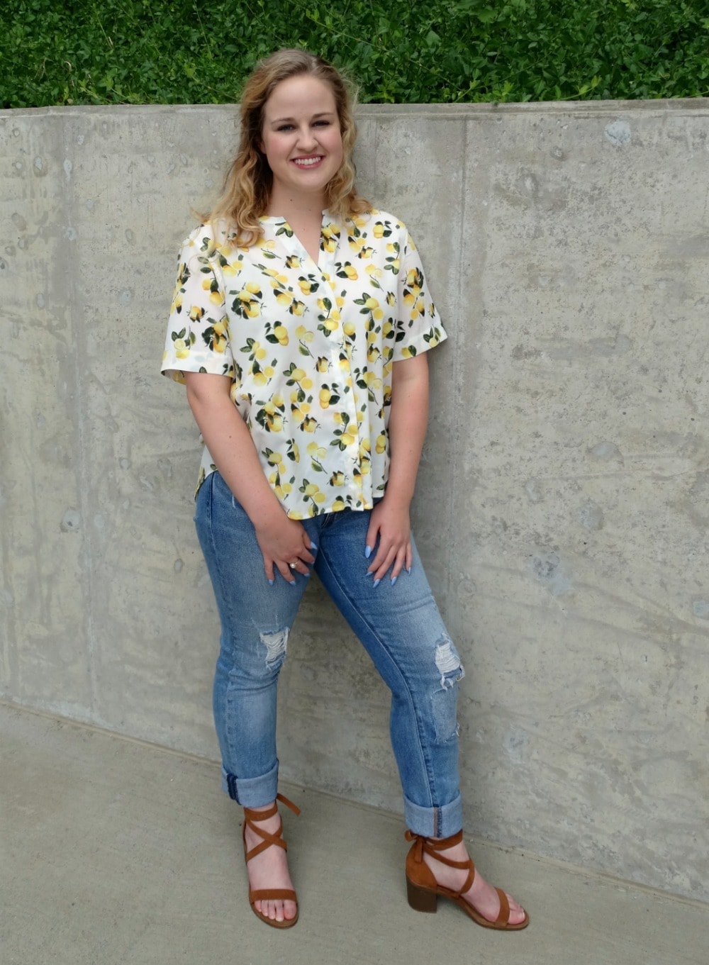 Student style on campus: lemon print short sleeved button up blouse paired with light-wash distressed denim jeans and brown lace-up sandals.