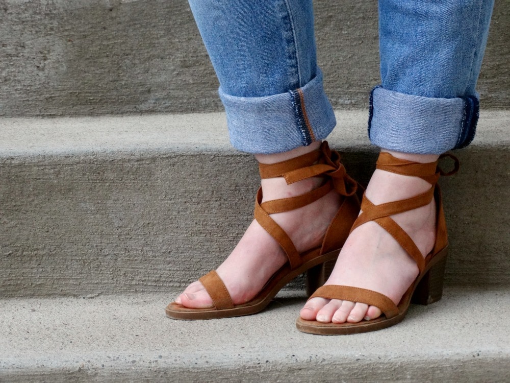 Cuffed jeans show off strappy brown sandals with a chunky heel.