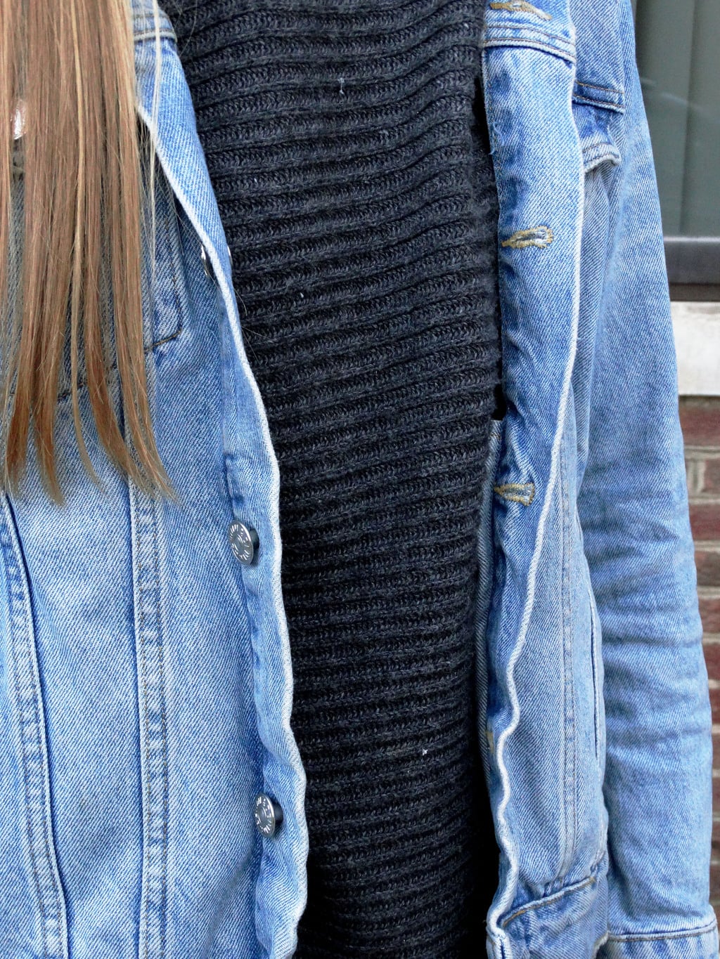 A West Virginia student wears a baggy ribbed cotton turtleneck grey sweater with a light-wash distressed denim jacket.