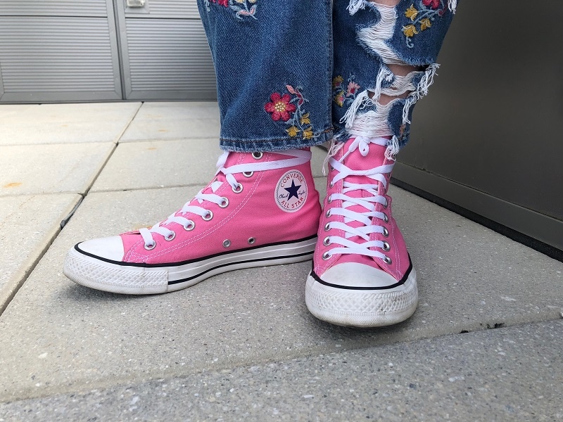 WVU student Maria wears high-top neon pink Converse sneakers.