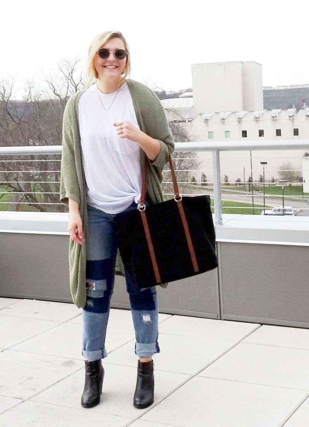 WVU college student Mel shows off her campus street style, wearing the perfect patchwork jeans outfit. Includes a white tee, boyfriend jeans, and an olive cardigan with heeled ankle booties