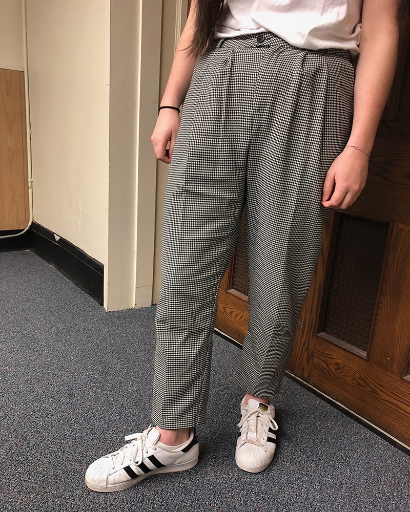 This WVU student wears high-waisted loose-fitted grey and white checkered slacks with her classic Adidas sneakers.