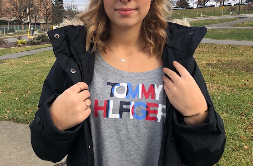 Sammy wears a soft, grey Tommy Hilfiger tee with black, white, blue, and red lettering.