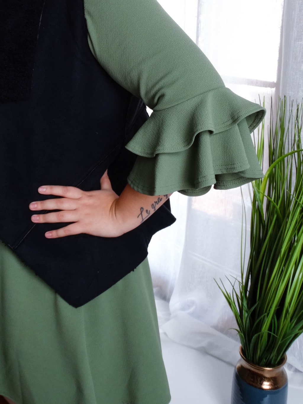 Sydney's green dress has layered ruffle sleeves.