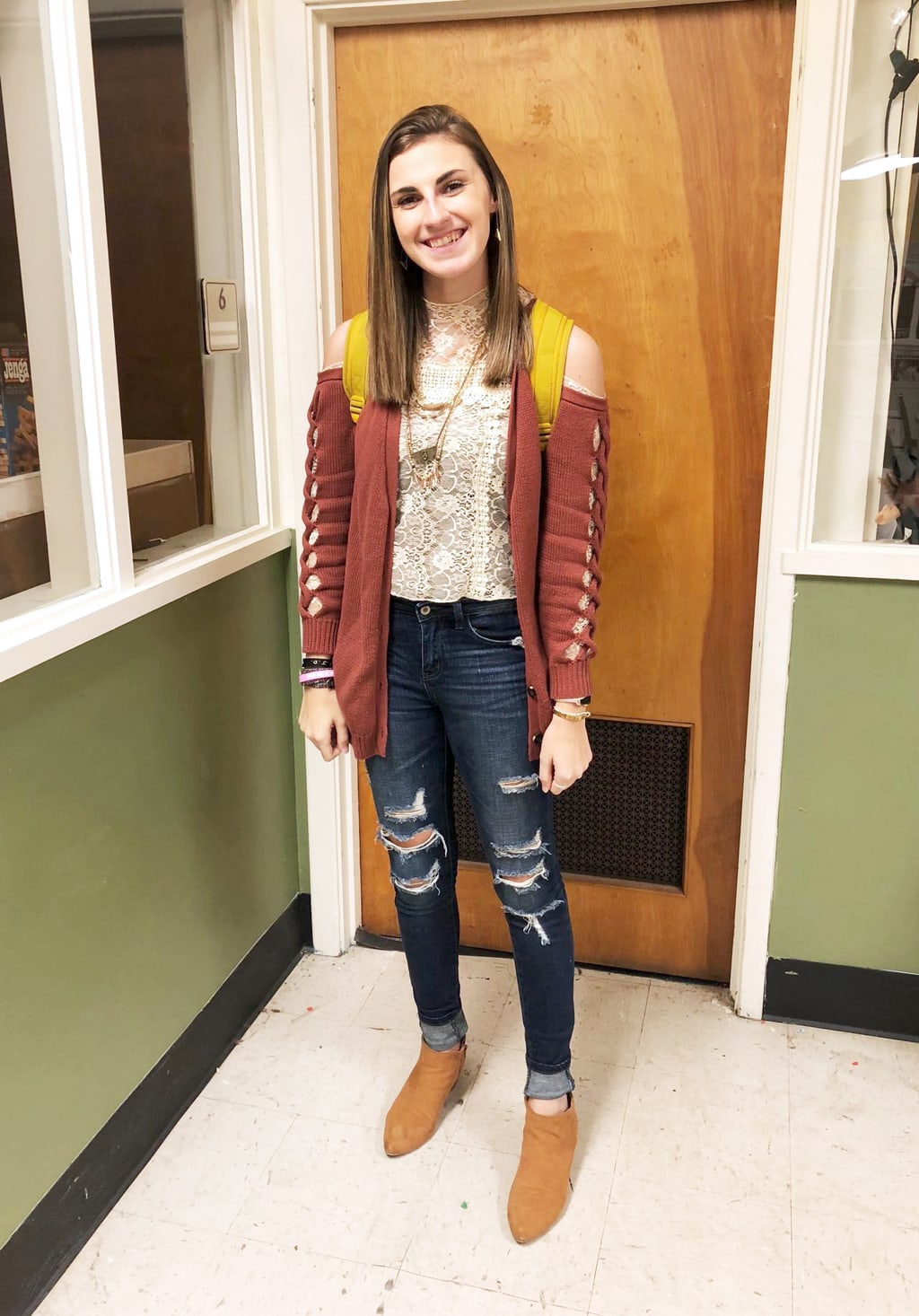 Gentry, a student at West Virginia University, wears a cropped lace high neck blouse with an open shoulder maroon cardigan and ripped jeans.