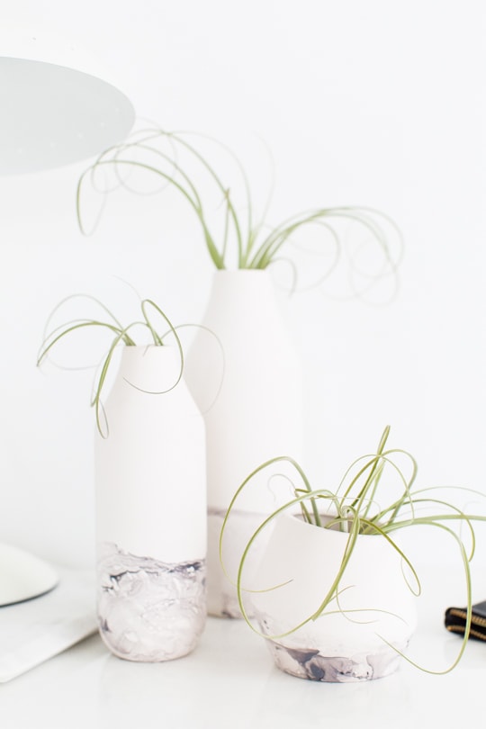 Photo including three vases with marble dipped bottoms.