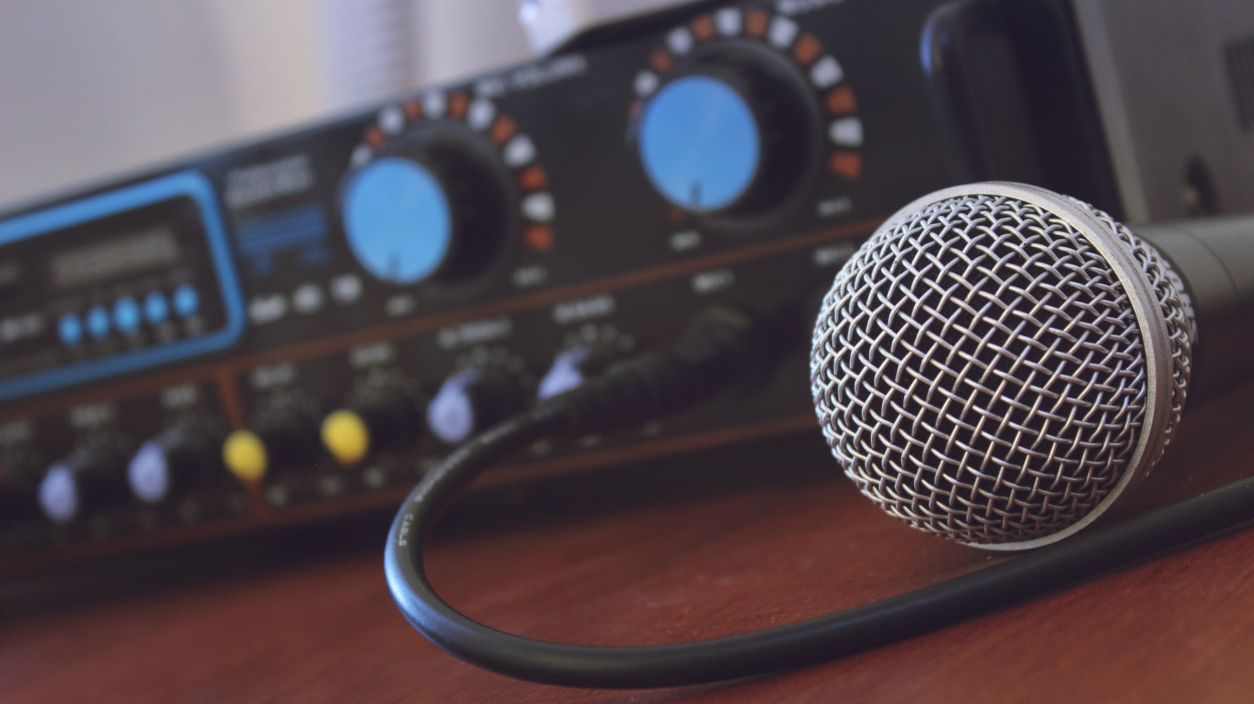 A microphone is set on a table, plugged into amplifier