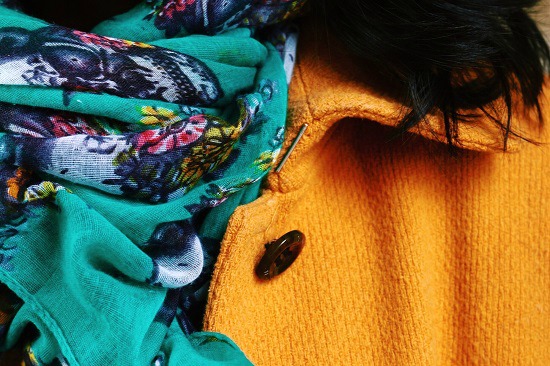 mustard yellow coat and teal scarf