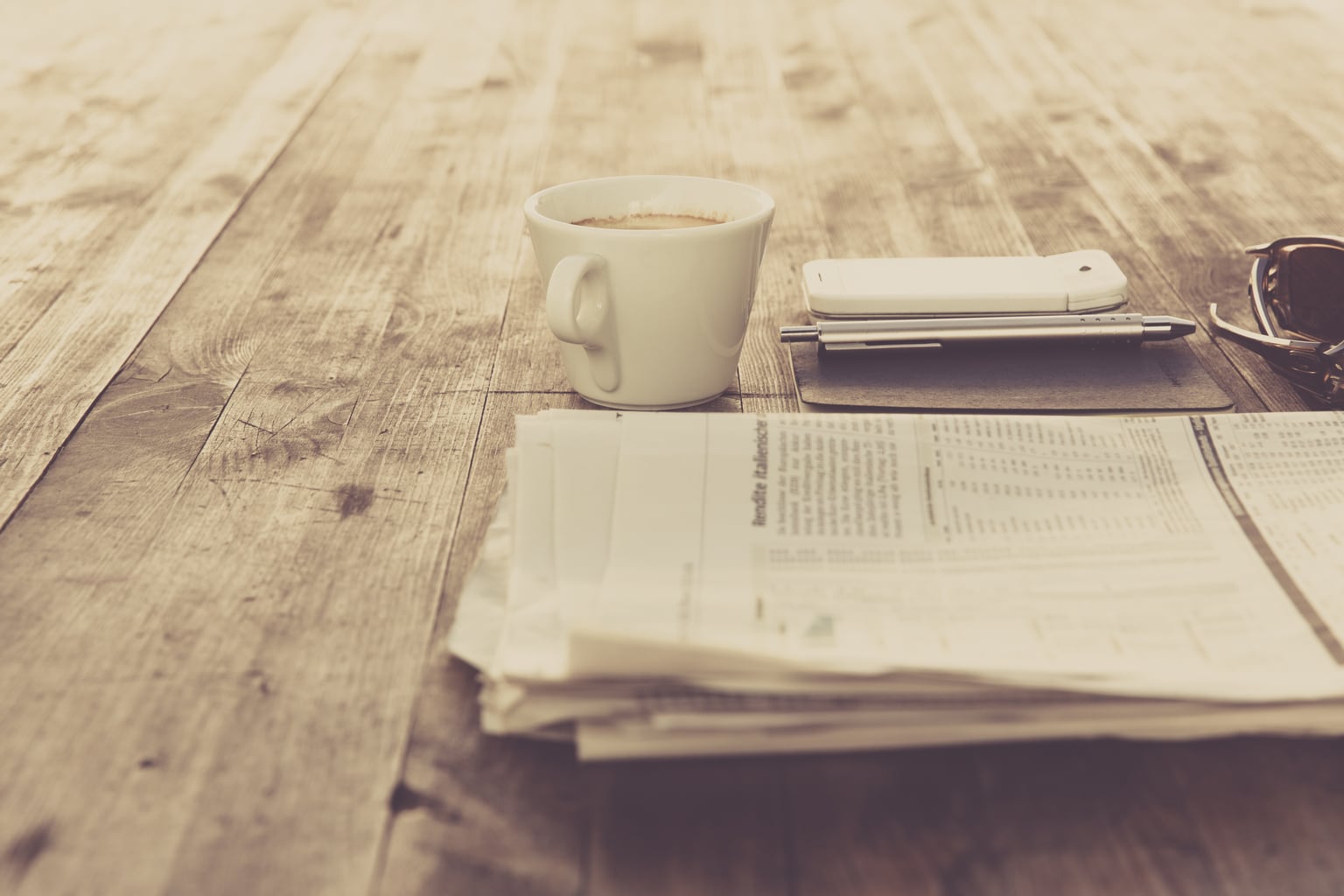 newspaper and coffee on a wooden table