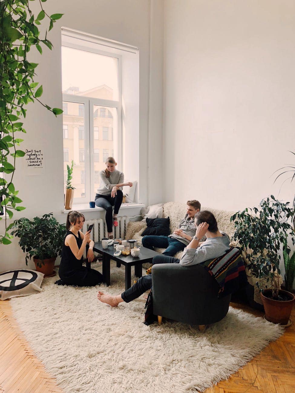 People gathered inside a living room with lots of plants