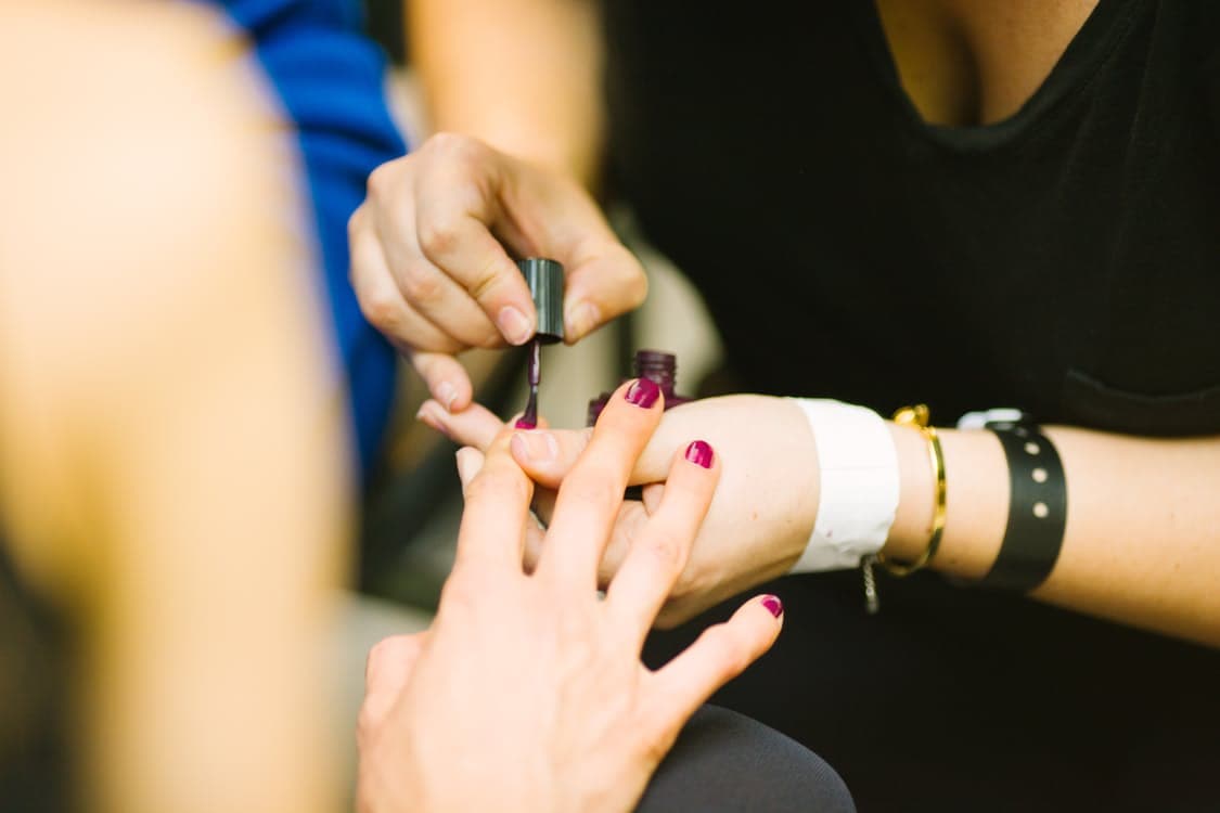 woman in black shirt painting nails