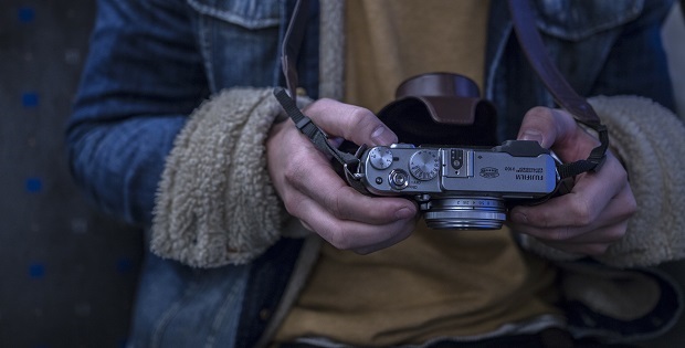 person in blue coat holding camera