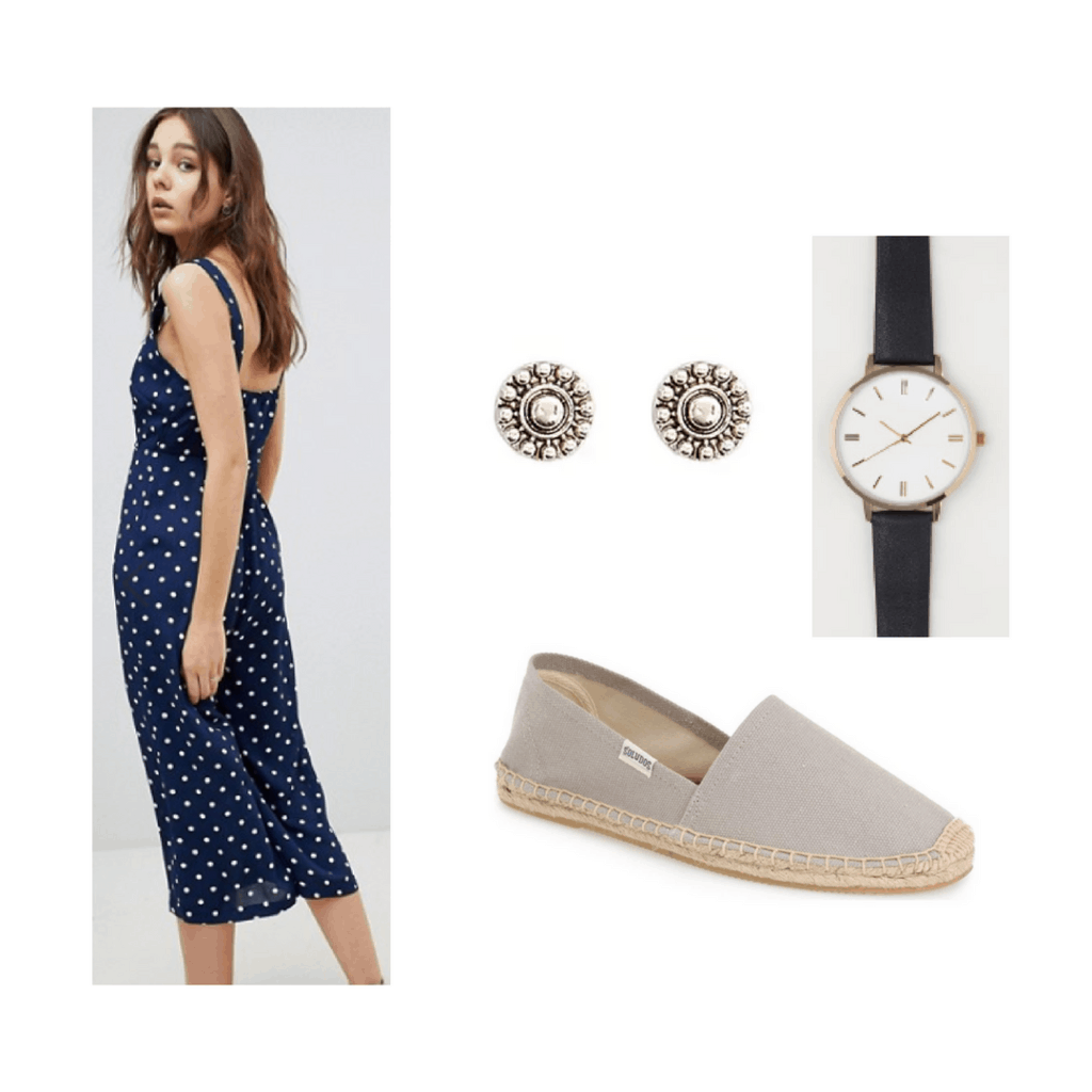 blue polka dotted jumpsuit with earrings, black watch and grey shoes