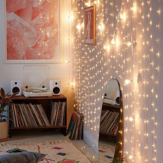 Pretty Christmas lights hung vertically up and down a wall in a dorm room