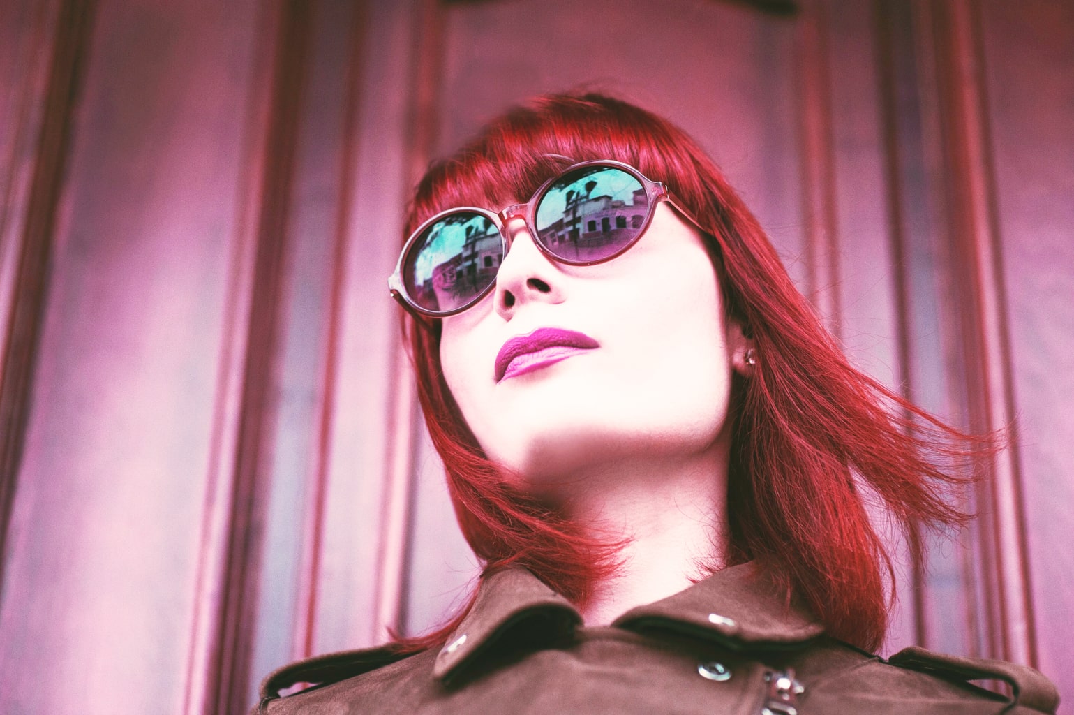 Woman with red hair wearing bold pink lipstick